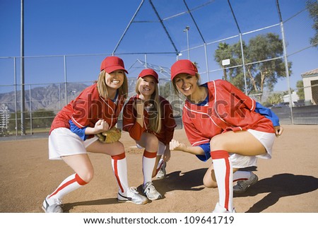 Portrait of three softball player cheering after a successful game