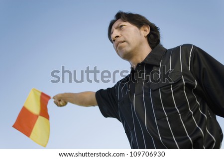 Low angle view of a soccer referee showing offside flag