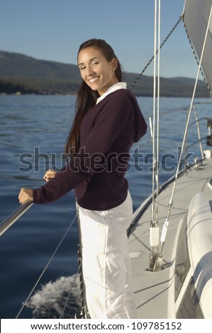 Portrait of a happy middle aged woman standing on sailboat