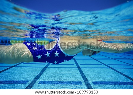 Side view of female participant swimming underwater