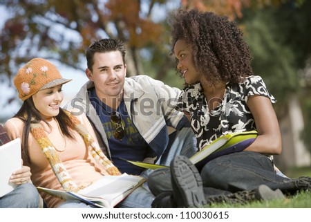 Man studying with two female friends at college campus