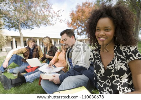 Young African American woman with friends studying at college campus