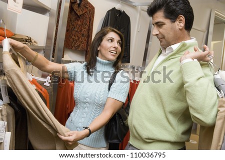 Middle aged couple choosing clothes in store