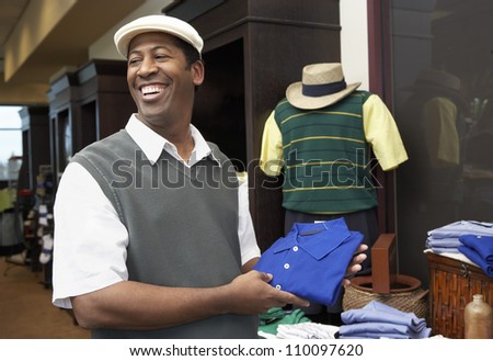 African American man buying clothes in clothing store