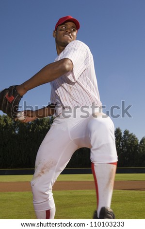 Young baseball pitcher winding up to throw the baseball