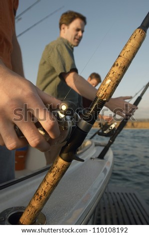 Mature man fishing with friends on yacht