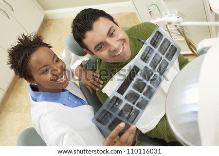 High angle view of dentist showing male patient tooth x-ray