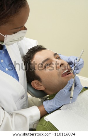 African American female dentist treating male patient