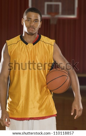 Portrait of a young African American player holding basketball