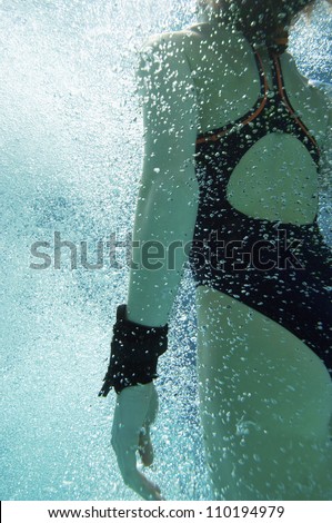 Middle aged Caucasian female diver swimming underwater