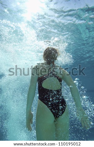 Rear view of a young female diver underwater