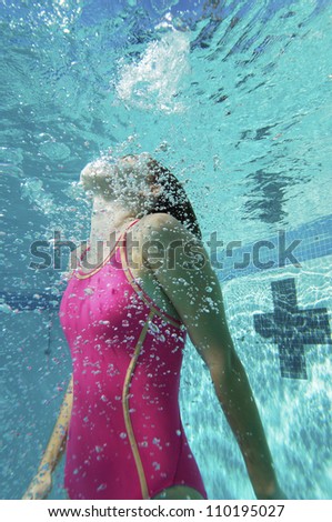 Young Caucasian female diver swimming underwater