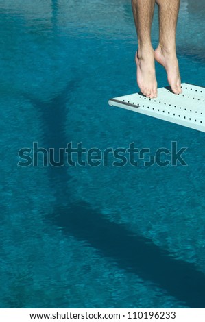 Low section of a male diver ready to jump from the springboard