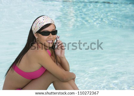 Young female in bikini sitting in pool