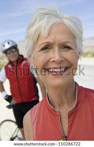 Happy senior woman with man in the background
