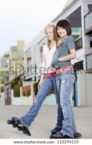 Young female friends in-line skating on street