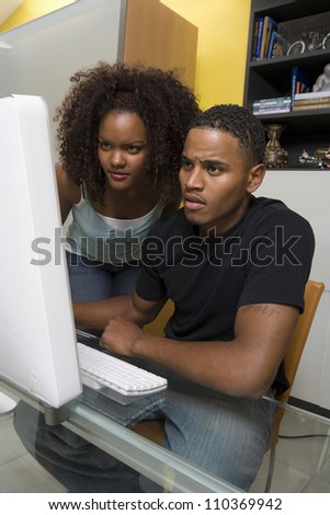 Worried young African American couple working on computer