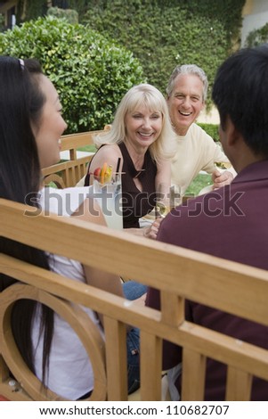 Mature couple with friends toasting wine together