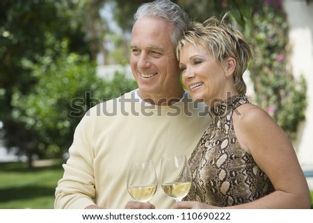 Mature caucasian couple toasting wine together
