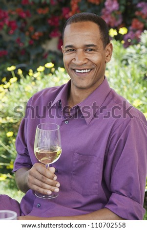 Happy African American man holding a wine glass