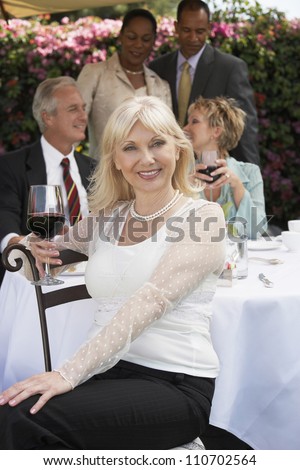 Portrait of a woman with glass of wine and friends