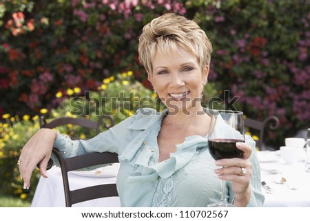 Portrait of a happy Caucasian woman holding a glass of wine