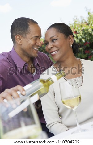 Middle aged African American couple celebrating together with wine