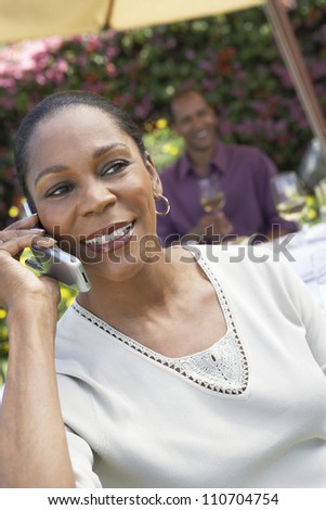 Happy middle aged African American woman using cell phone
