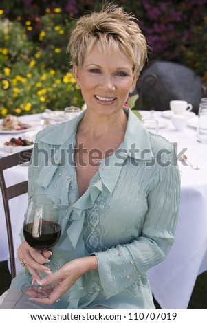 Portrait of a happy Caucasian woman with a glass of wine