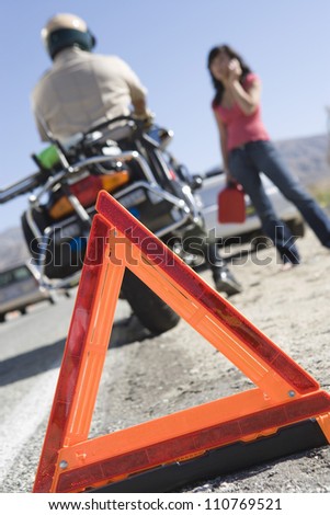 Close-up of a warning triangle with woman and traffic cop