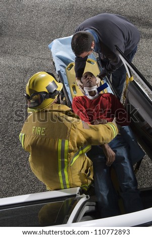 Firefighter and doctor taking out victim from car