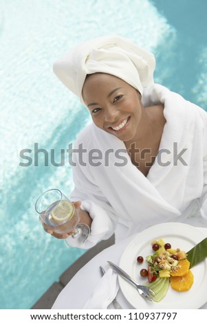 High angle view of a woman having healthy food by swimming pool