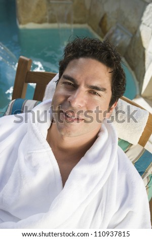 Man relaxing on spa chair by a pool