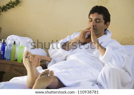 Hispanic man relaxing on spa chair