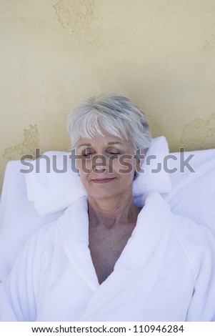 Happy senior woman relaxing in a spa with closed eyes