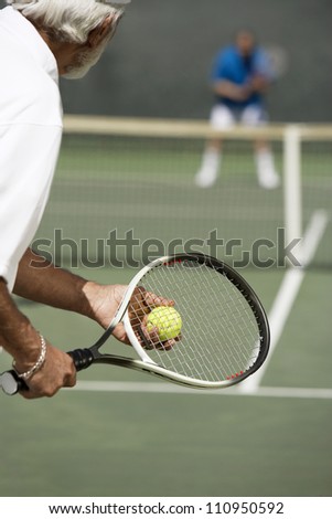 Senior tennis player with racket ready to serve a tennis ball