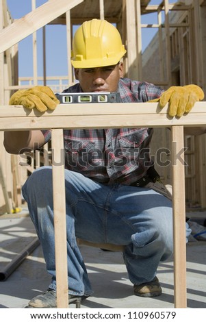 Worker measuring form work at construction site