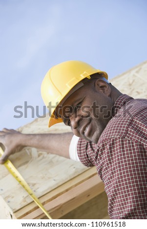 Worker measuring form work at construction site