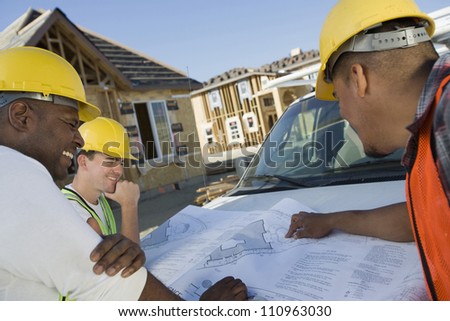 Team of workers discussing over a blueprint