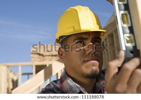 Builder examining framework at construction site