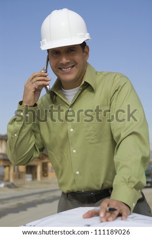 Happy architect on call at construction site