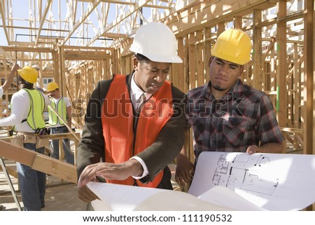 Architect and builder discussing at construction site