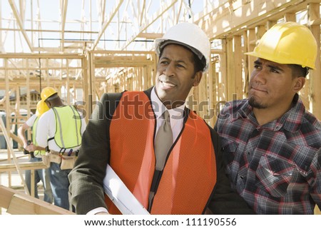 Architect and builder talking at construction site
