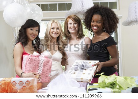 Portrait of bride and friends holding gifts at  party