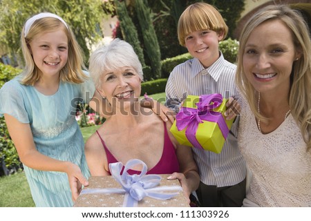 Portrait of children\'s giving gifts to grand mother on birthday
