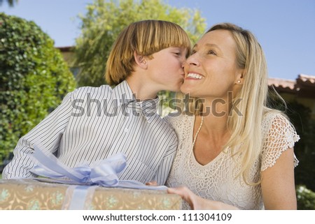 Happy mother giving gift to son at birthday