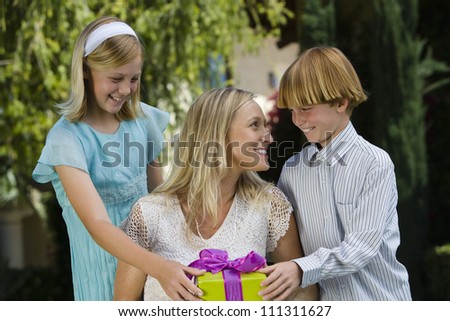 Happy mother receiving gift from kids on her birthday
