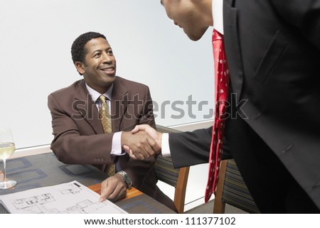 Happy business people shaking hands at office