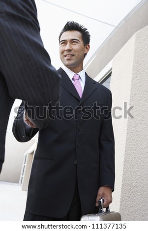 Happy business people in suit shaking hands