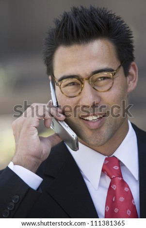 Portrait of happy Asian businessman on call